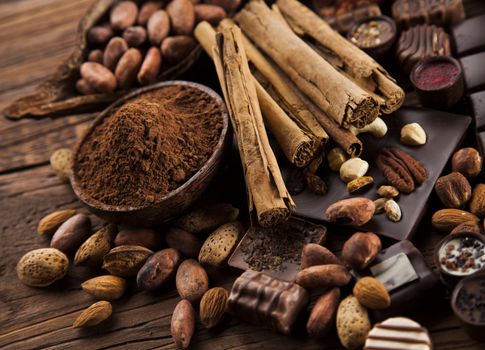 Chocolate bars and pralines on wooden background