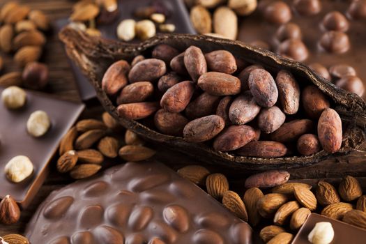 Dark homemade chocolate bars and cocoa pod on wooden