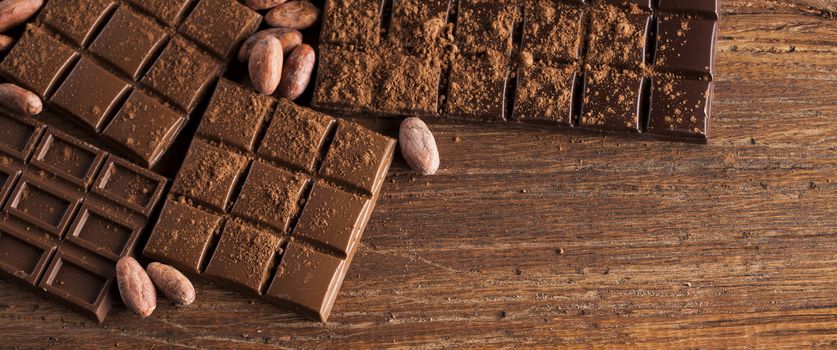 Milk and dark chocolate on a wooden table