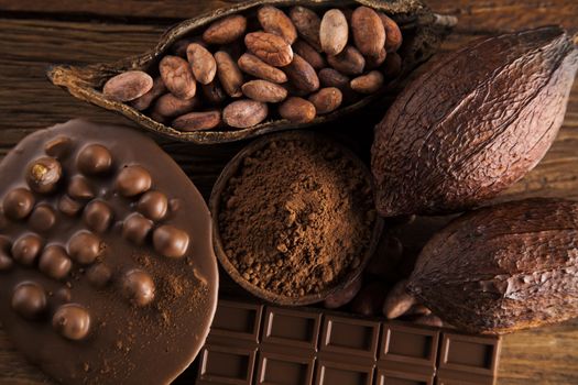 Aromatic cocoa and chocolate on wooden background