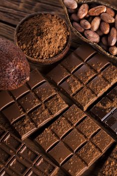 Aromatic cocoa and chocolate on wooden background