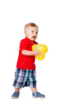 baby boy standing on the floor with a yellow balloon