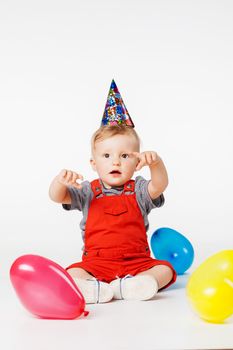 baby boy with birthday hat and balloons