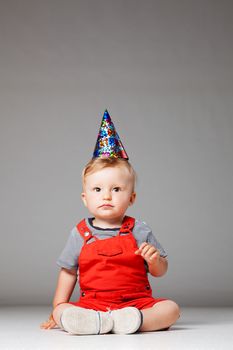 happy baby boy with birthday hat, studio shot