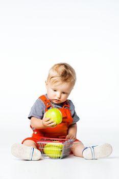 baby boy playing with green and red apples