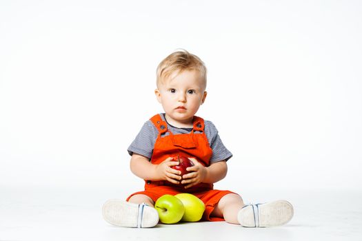 baby boy playing with green and red apples