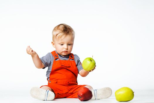 baby boy playing with green and red apples