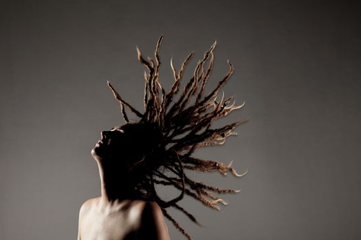 portrait of a caucasian girl with dreadlocks flying in the air