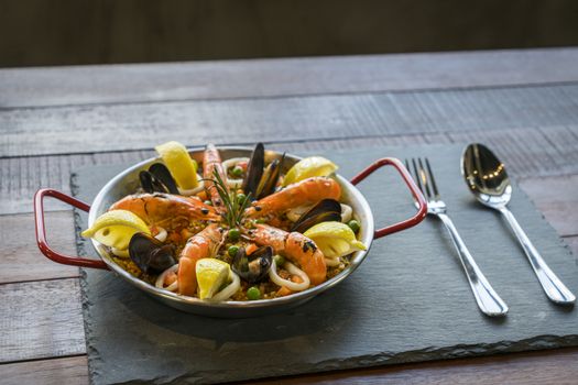 Paella with seafood vegetables and saffron served in the traditional pan