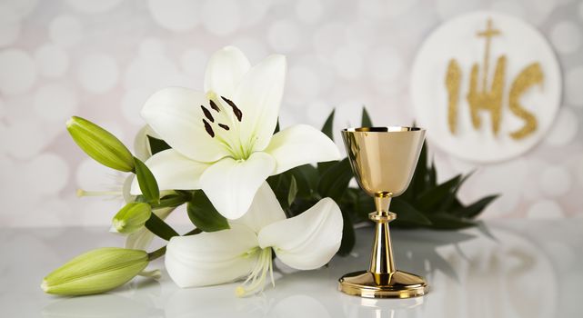 Holy communion a golden chalice with grapes and bread wafers