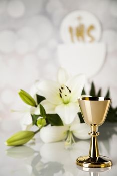 Holy communion a golden chalice with grapes and bread wafers