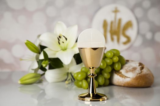 Holy communion a golden chalice with grapes and bread wafers