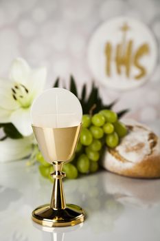 Holy communion a golden chalice with grapes and bread wafers