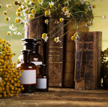 Book and Herbal medicine on wooden table background