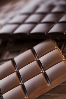 Milk and dark chocolate on a wooden table