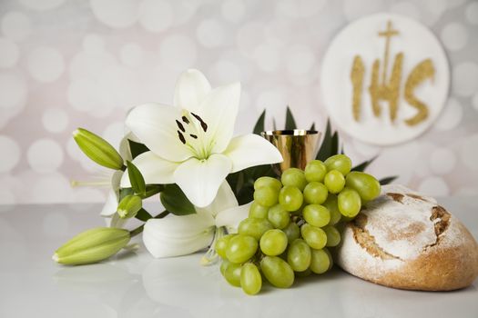 Holy communion a golden chalice with grapes and bread wafers