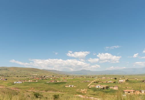 Smallholdings with houses and corn fields on the road to Injisuthi in the Kwazulu-Natal Drakensberg