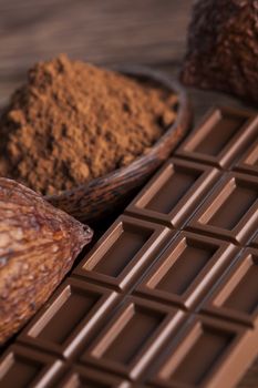 Aromatic cocoa and chocolate on wooden background