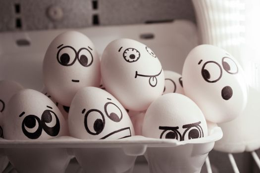Concept of gossip in a group of people. Face eggs are funny in the fridge. Photo for your design. Group of eggs with open mouth