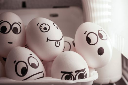 Concept of gossip. Face eggs are funny in the fridge. Photo for your design. Group of eggs with open mouth