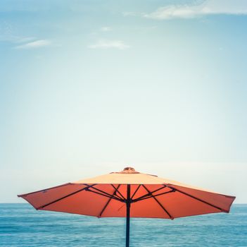 Retro Style Vacation Image Of A Beach Umbrella Against The Ocean With Copy Space