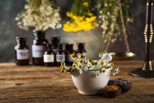 Natural medicine, herbs, mortar on wooden table background