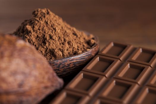 Aromatic cocoa and chocolate on wooden background