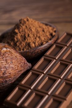 Aromatic cocoa and chocolate on wooden background