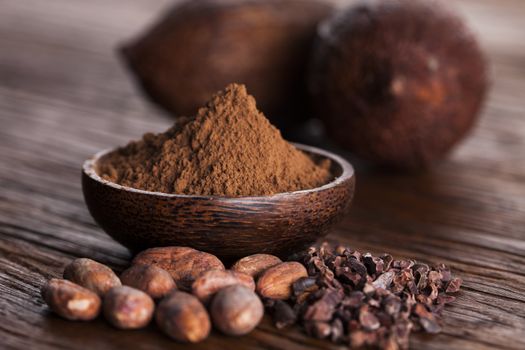 Cocoa beans in the dry cocoa pod fruit on wooden background