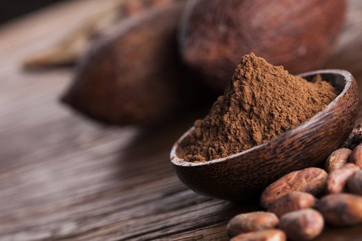 Cocoa beans in the dry cocoa pod fruit on wooden background