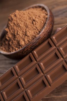 Aromatic cocoa and chocolate on wooden background