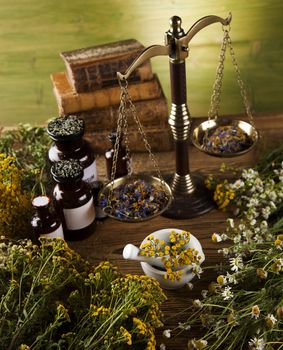 Herbal medicine and book on wooden table background