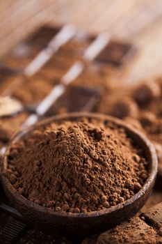 Dark homemade chocolate bars and cocoa pod on wooden