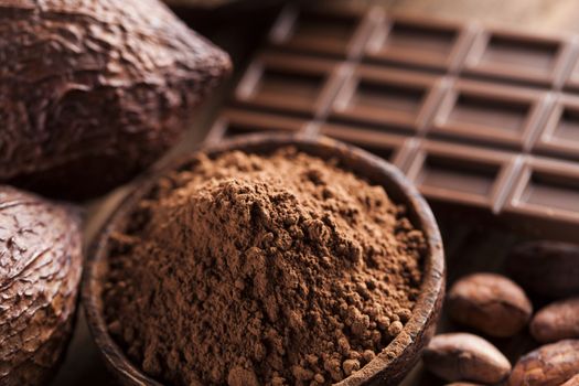 Aromatic cocoa and chocolate on wooden background