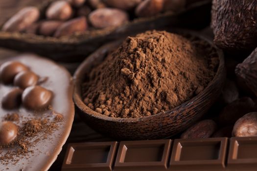 Aromatic cocoa and chocolate on wooden background