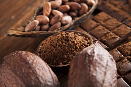 Dark homemade chocolate bars and cocoa pod on wooden