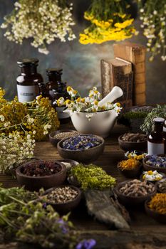 Natural medicine, herbs, mortar on wooden table background