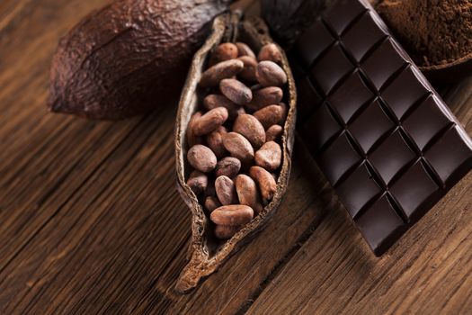 Aromatic cocoa and chocolate on wooden background