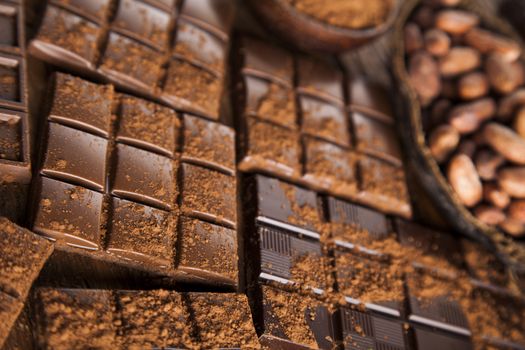 Aromatic cocoa and chocolate on wooden background