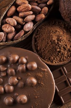 Aromatic cocoa and chocolate on wooden background