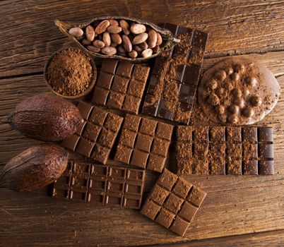 Dark homemade chocolate bars and cocoa pod on wooden