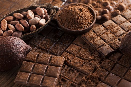 Dark homemade chocolate bars and cocoa pod on wooden