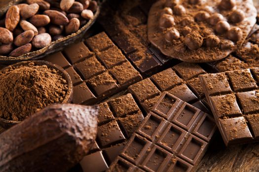 Aromatic cocoa and chocolate on wooden background