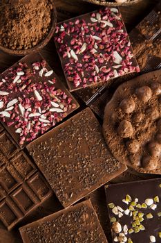 Dark homemade chocolate bars and cocoa pod on wooden