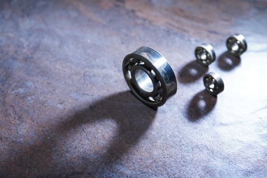 Set of  ball bearings on dark background with long shadow