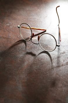 Closeup of old spectacles on dark background with shadow