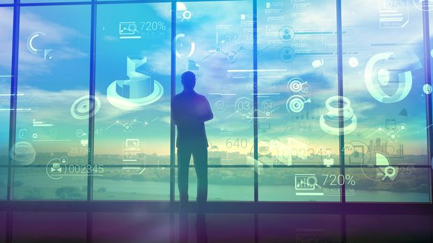 A businessman in the background of a window is carefully studying a lot of corporate data. Silhouette stands in a large office building in front of a panoramic glass window.