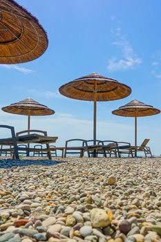 Beach with beach chairs in morning light on the beach of a Croatian seaside holiday resort in Porec, Istria, no people