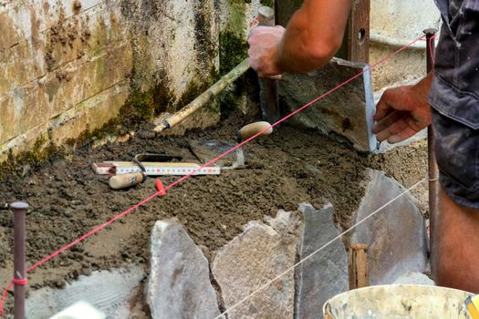 Workers at the laying and clipping of natural stone plates
