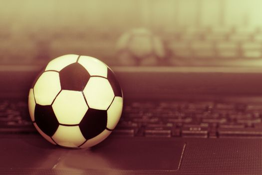 Souvenir soccer ball on the laptop keyboard. The concept of a football match